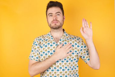 Eli göğsünde ve avucu açık yemin eden yakışıklı genç adam sadakat yemini ediyor.