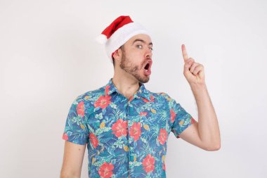 Noel Baba şapkalı genç adam başarılı bir fikir işaret ediyor. Heyecanlı ve mutlu. Bir numara..