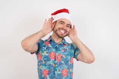 Noel Baba şapkalı genç adam iki eliyle kulak hareketi yapmaya çalışıyor. Dedikoduya meraklı. İşitme problemi, sağır