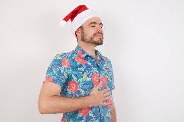 Noel Baba şapkalı genç adam karnına dokunuyor, nazikçe gülümsüyor, yemek yiyor ve tatmin oluyor..