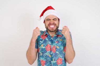 Noel Baba şapkalı genç adam kollarını kaldırdı ve gözleri kapalı zaferi kutluyor. Kazanan konsept.