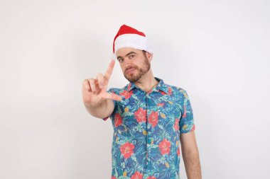 Noel Baba şapkalı genç adam parmakları olan insanlarla dalga geçiyor. Ezik jestler yapıyor, alay ediyor ve hakaret ediyor..