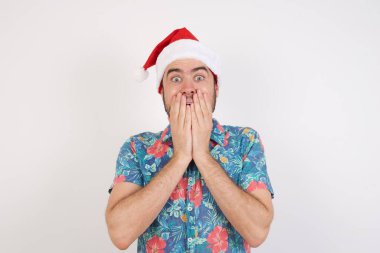 Noel Baba şapkalı genç adam neşe içinde kıkırdıyor, ağzını kapatıyor, tek başına eğleniyor, olumlu bir hikaye ya da komik bir anekdot duyuyor.