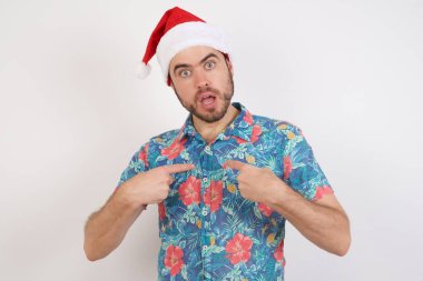 Noel Baba şapkalı genç adam şaşkın bir ifadeyle kendini gösteriyor.  