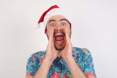 Noel Baba şapkalı genç adam heyecanla bağırıyor..