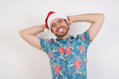 Noel Baba şapkalı genç adam kollarını açıyor, rahat pozisyonda.. 