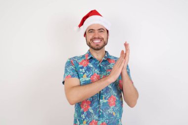  Noel şapkası takan, alkışlayan mutlu ve neşeli gülümseyen, gururlu elleri bir arada tutan bir adam..