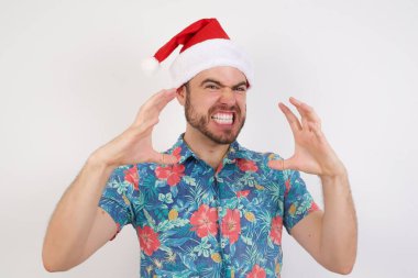 Noel Baba şapkalı genç adam öfkeyle bağırıyor, elleri boğazlamaya çalışıyor, deli gibi bağırıyor..