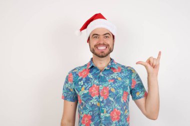 6 numaralı Noel Baba şapkalı genç adam parmaklarıyla işaret Çince dilini işaret ediyor.