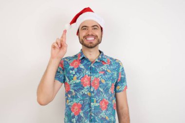 Noel Baba şapkalı genç adam Çince işaret dilinde on numarayı işaret ediyor.