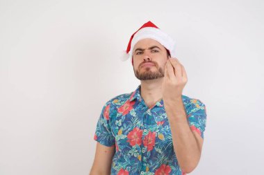 Noel Baba şapkalı genç adam tipik İtalyan jestleri yapıyor, kameraya bakıyor.