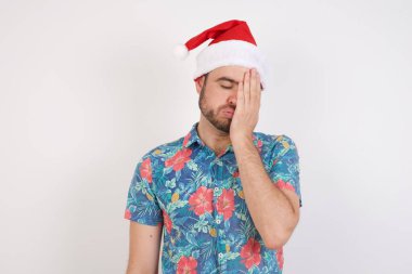 Noel Baba şapkalı genç adam uykulu bir ifadeye, kasvetli bir bakışa, yüzle kaplanmış bir ele, gözleri kapalı, yorgunluktan soluk soluğa kalmış, partiden sonra bitkinliğe kapılmış.