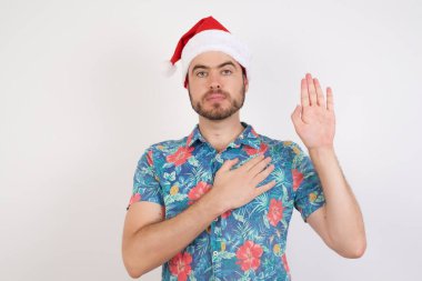 Noel Baba şapkalı genç adam el pençe divan durup sadakat yemini ediyor.