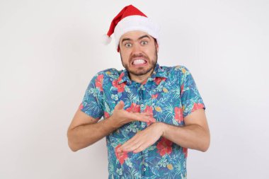 Noel Baba şapkalı genç adam. Aceleyle saati izlemek için işaret ediyor. Sabırsızlık, gecikme yüzünden kızgın ve kızgın..