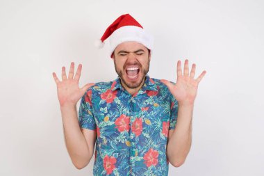 Noel Baba şapkalı genç adam yüksek sesle gülüyor, komik fıkra ya da hikaye duyuyor, avuçlarını zevkle kaldırıyor, aşırı sevinçle eğleniyor, arkadaşı tarafından eğlendiriliyor. İnsanlar ve duygular.