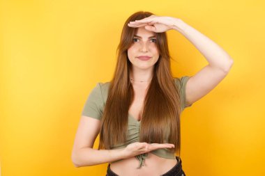 Elleri büyük ve büyük bir işaret gösteren güzel genç bir kadın. Ölçü sembolü. Kameraya bakıp gülümsüyor. Ölçüm konsepti.