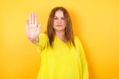 Güzel, olgun bir kadın avucuyla hareket etmeyi kesiyor. Olumsuz ve ciddi jest içeren uyarı ifadesi  