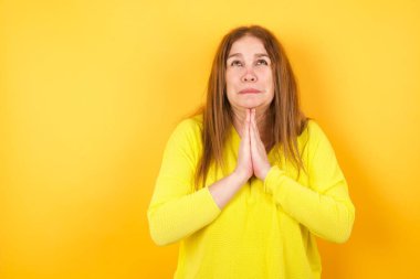 Güzel, olgun bir kadın elleri bağlı yalvarıyor ve dua ediyor. Yüzünde umut ifadesi var. Çok duygusal ve endişeli. Soruyorum.