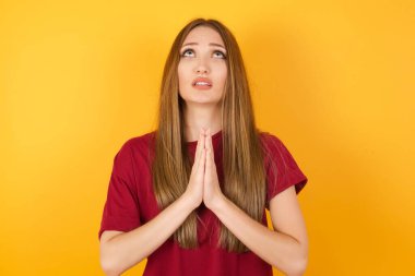 Güzel genç bir kadın elleri bağlı yalvarıyor ve dua ediyor. Yüzünde umut ifadesi var. Çok duygusal ve endişeli. Soruyorum.