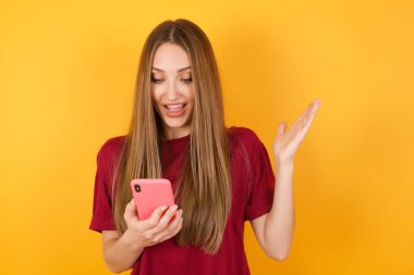 Güzel genç bayan yeni akıllı telefon kullanıyor.