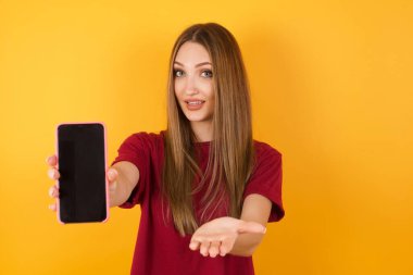 Stüdyodaki kadın akıllı telefon sunuyor. 