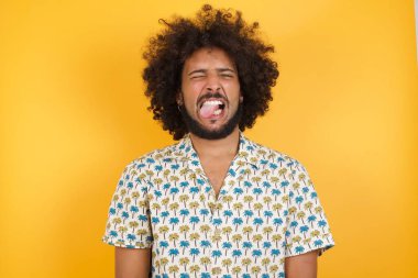 Yakışıklı genç adam komik bir ifadeyle dilini dışarı çıkartıyor. Duygu kavramı.