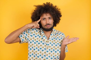 Yakışıklı genç adamın kafası karışmış ve avuç içi açık fotokopi alanı ve alnını göstermekten rahatsız olmuş. Bunu bir düşün..