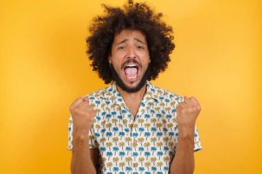 Yakışıklı genç adam kollarını kaldırıp gözlerini açarak başarıya hayran kaldı. Kazanan konsept.