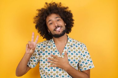 Eli göğsünde ve parmakları havada yemin eden yakışıklı genç adam sadakat yemini ediyor..