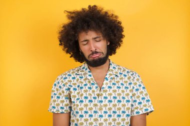 Yakışıklı genç adam alt dudağını kıvırır ve umutsuzluk içinde gözlerini kapatır, depresyondadır.  