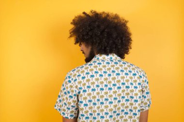 Sarı duvarın önünde duran adamın arka tarafı. Stüdyo Çekimi.