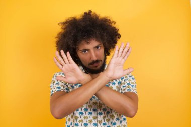 Yakışıklı genç adam kollarını kavuşturuyor ve avuç içleri negatif işaretler veriyor, kızgın surat..