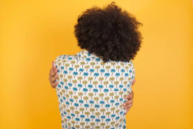 Yakışıklı genç adam, mutlu ve olumlu bir şekilde kendini kucaklıyor. Sevgi ve özgüven.