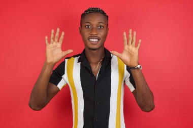 Genç adam kendini beğenmiş ve mutlu bir şekilde gülümserken on numarayı işaret ediyor..