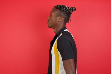 Yandan bakan genç adam, rahat profil pozu doğal bir yüz ve kendine güvenen bir gülümseme..