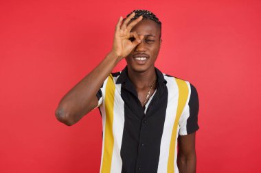 Yakışıklı genç adam iyi bir jest yapıyor. Şaşırmış bir yüz, parmaklarından bakan gözler. İnançsız ifade.