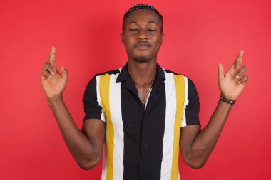 Yakışıklı genç adam şans diliyor, iyi şansa inanıyor, geniş bir şekilde gülümsüyor. İnsanlar ve dilek kavramı