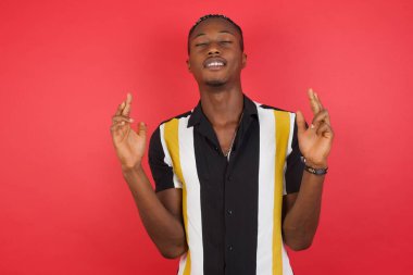 Yakışıklı genç adam umut ve gözleri kapalı gülümseyerek bana işaret ediyor. Şans ve batıl inanç..