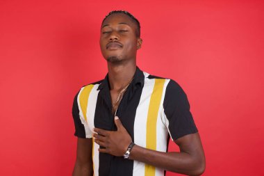 Yakışıklı genç adam göbeğine dokunur, nazikçe gülümser, tatmin olur..