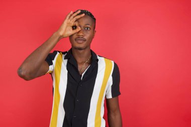 Yakışıklı genç adam el hareketleriyle gülümsüyor, gözleriyle mutlu yüzüyle parmaklarından bakıyor..