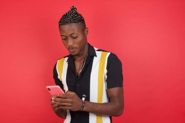 Stüdyoda elinde cep telefonu olan Afrikalı Amerikalı bir adam var.