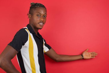 Yakışıklı genç adam mutlu ve neşeli hissediyor, gülümsüyor ve seni selamlıyor, dostça bir jestle içeri davet ediyor. 