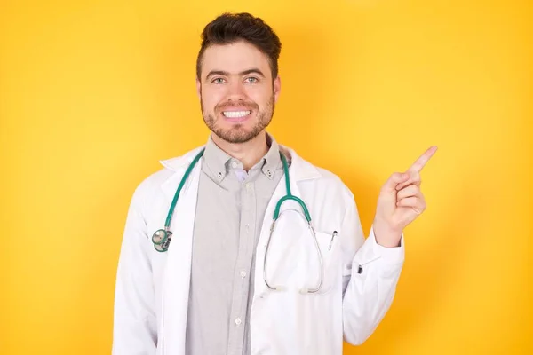 Χαμογελαστή Γιατρός Άνθρωπος Φορώντας Ιατρική Στολή Που Δείχνει Δάχτυλο Κενό — Φωτογραφία Αρχείου