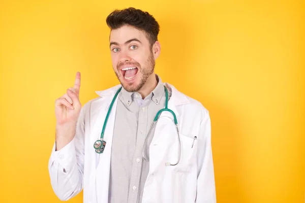 Genç Yakışıklı Doktor Parmağını Kaldırıyor Fikri Var Sarı Arka Planda — Stok fotoğraf