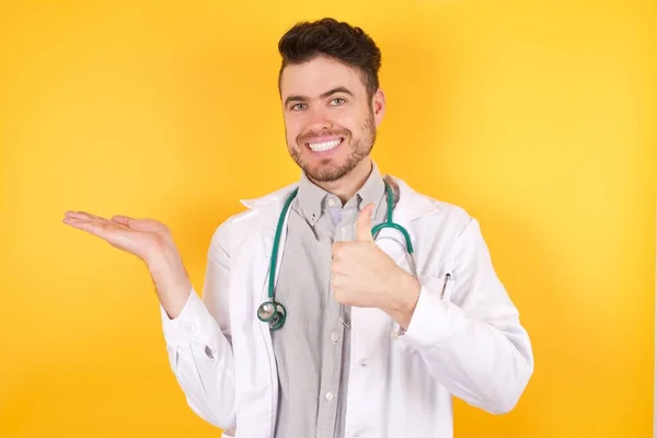 Joven Hombre Caucásico Guapo Con Uniforme Médico Estetoscopio Mostrando Palma — Foto de Stock