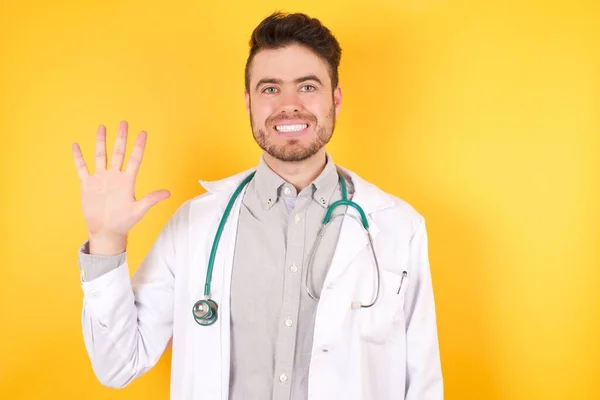 유럽의 잘생긴 의사가 자신감 행복하게 웃으면서 손가락으로 가리키며 유니폼을 — 스톡 사진