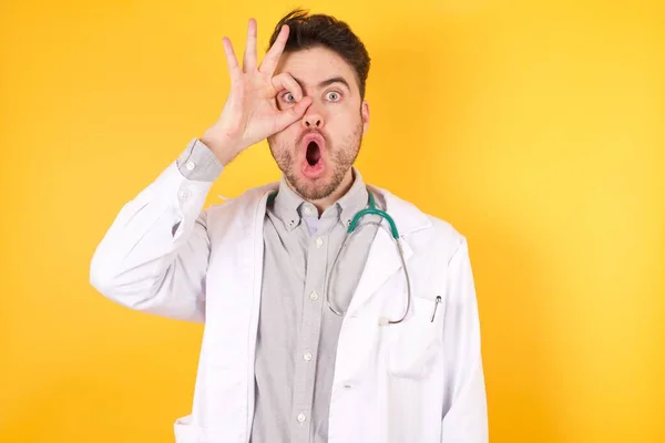 Joven Guapo Médico Caucásico Vestido Uniforme Médico Pie Sobre Fondo — Foto de Stock