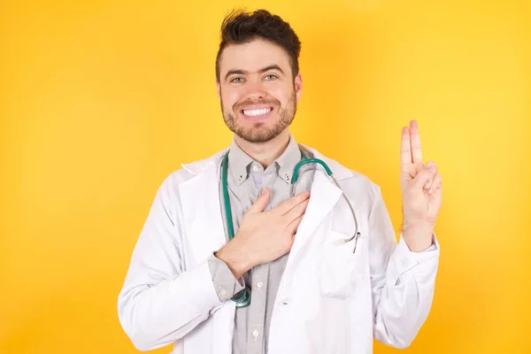 Νεαρός Όμορφος Καυκάσιος Γιατρός Ιατρική Στολή Χαμογελαστός Ορκίζεται Χέρι Στο — Φωτογραφία Αρχείου