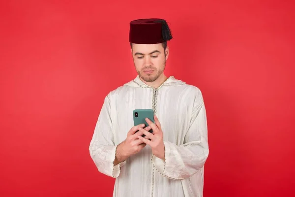 Pohledný Mladý Muž Sobě Tradiční Turkyně Klobouk Fez Pomocí Smartphone — Stock fotografie