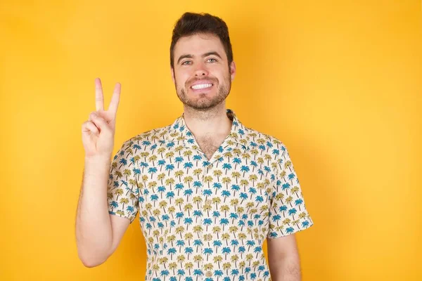 Pohledný Mladý Muž Ukazuje Prsty Číslo Dvě Při Úsměvu Sebevědomý — Stock fotografie
